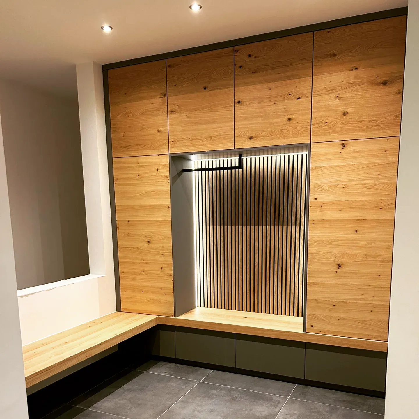 Garderobe in Eiche mit beleuchteter Nische, Lamellenrückwand und Sitzbank
