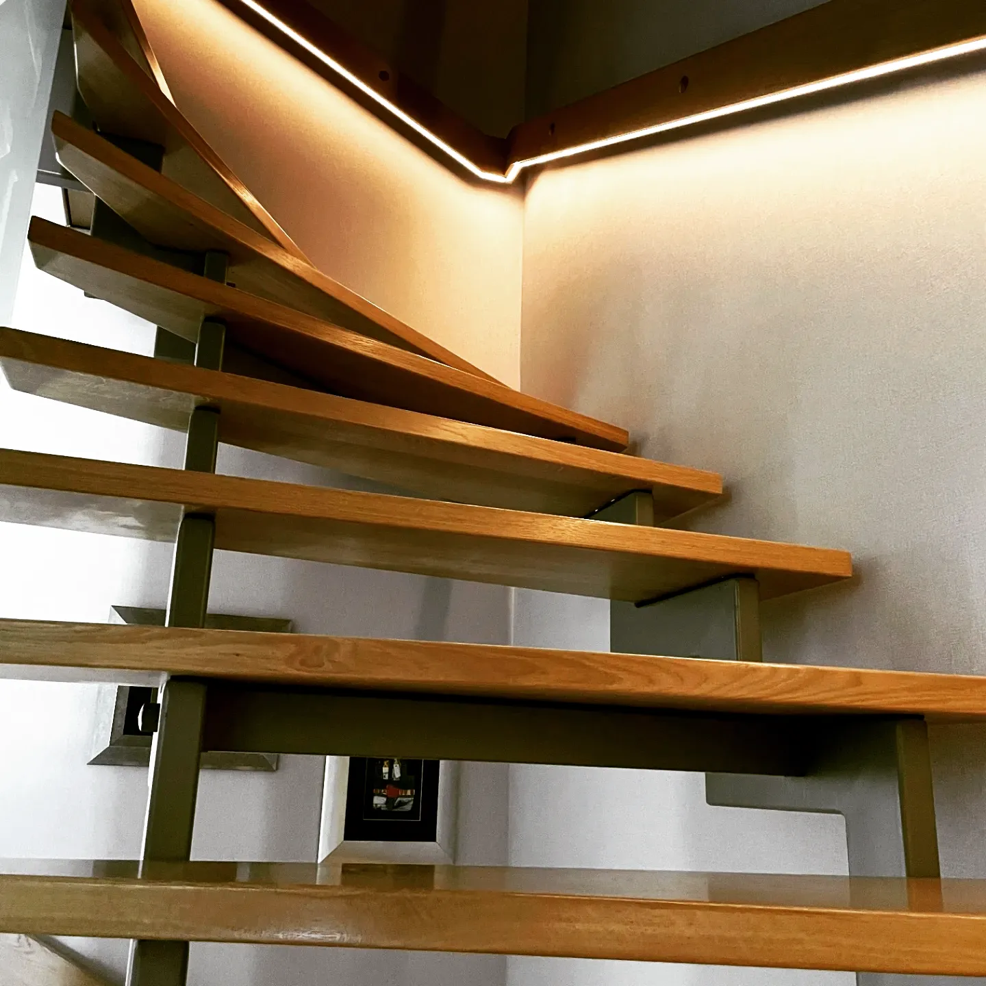 Holztreppe mit indirektem LED-Lichtband, gefertigt von der Schreinerei Neubig