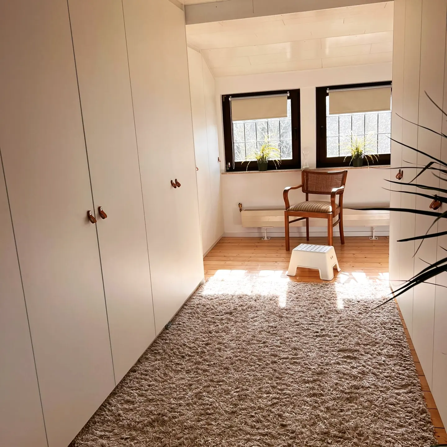 Weiße Kleiderschrankwand im hellen Schlafzimmer