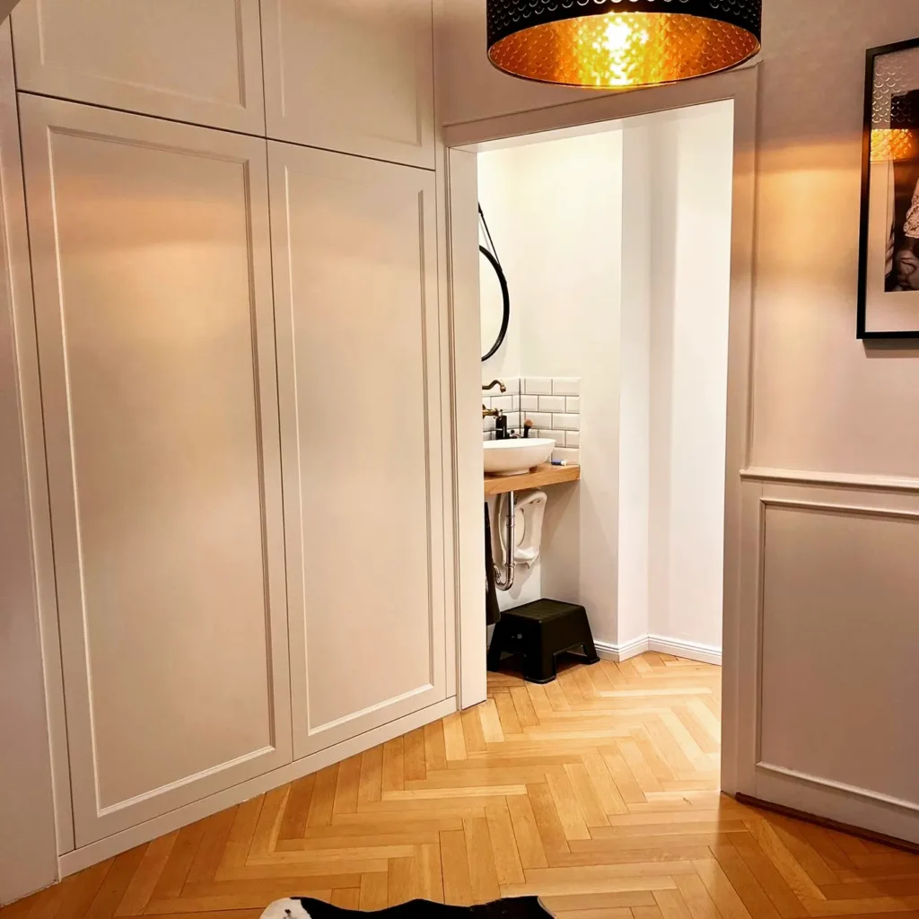 Ein Zimmer mit Parketboden, Waschnische und Schränken